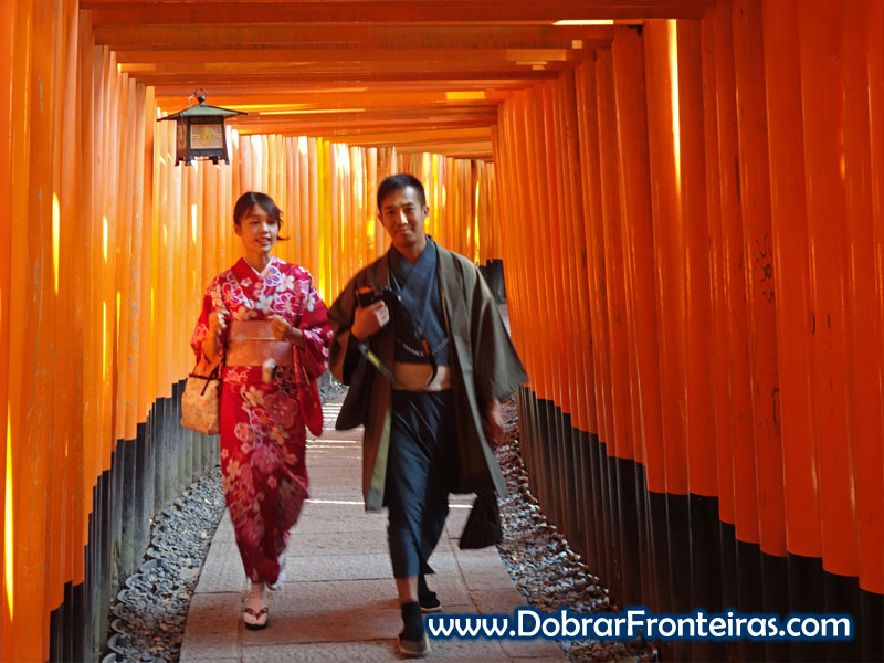 Casal de japoneses usando roupas típicas no meio dos Torii