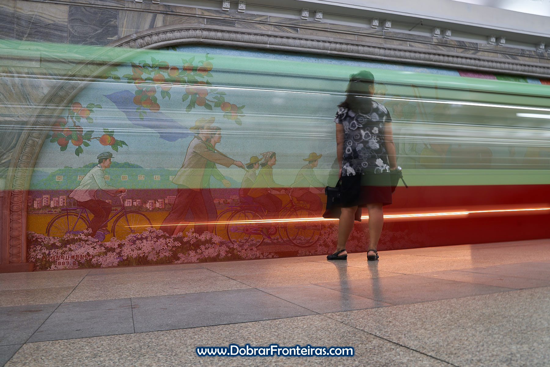 Longa exposição com comboio e mulher no metropolitano de Pyongyang